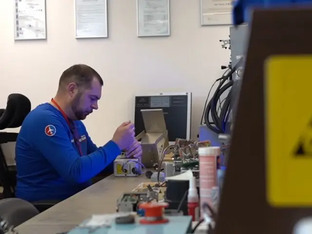 Technician repairing an autopilot unit at an ESD workbench