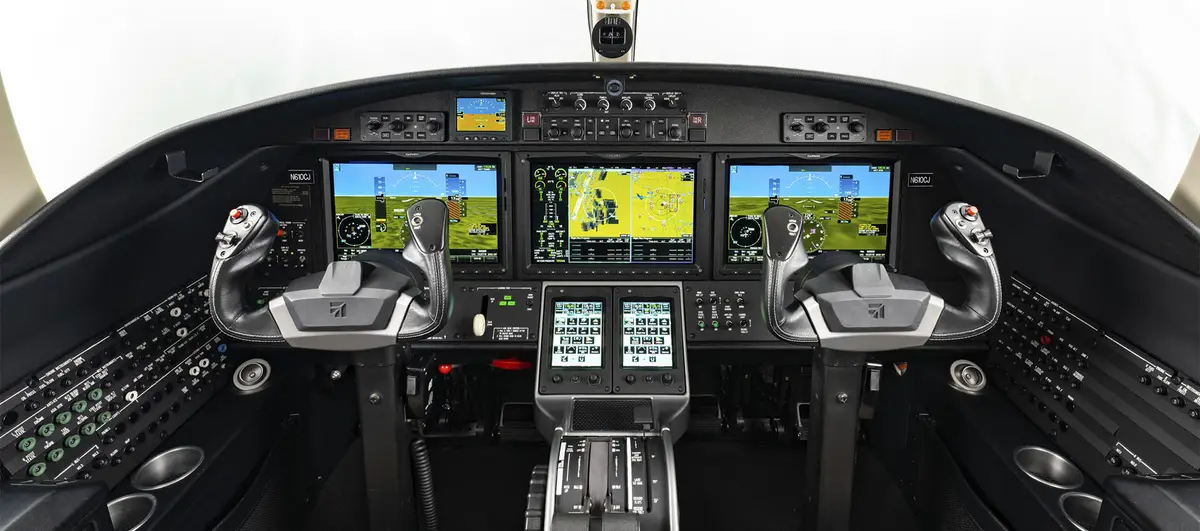 Modern integrated glass cockpit with digital flight displays and touchscreen controllers