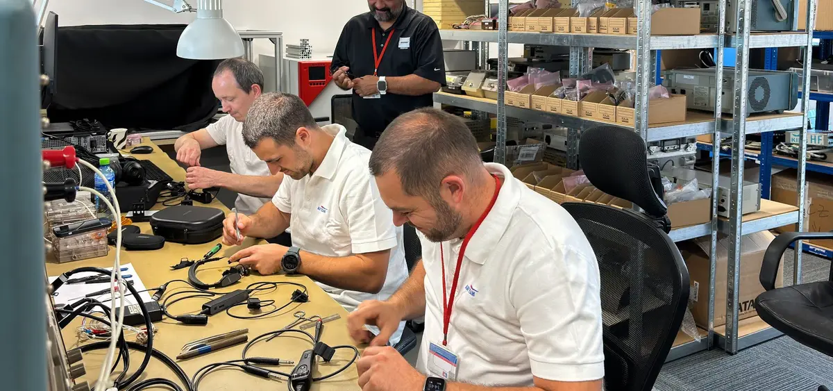 Technicians repairing avionics and headsets at benches in the Veverská Bítýška component shop
