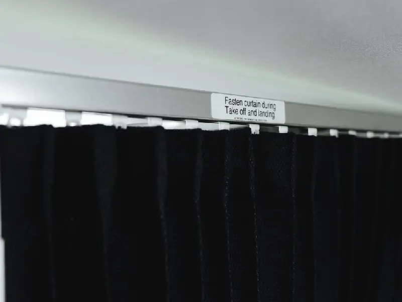 Black crew-rest curtain on a ceiling rail