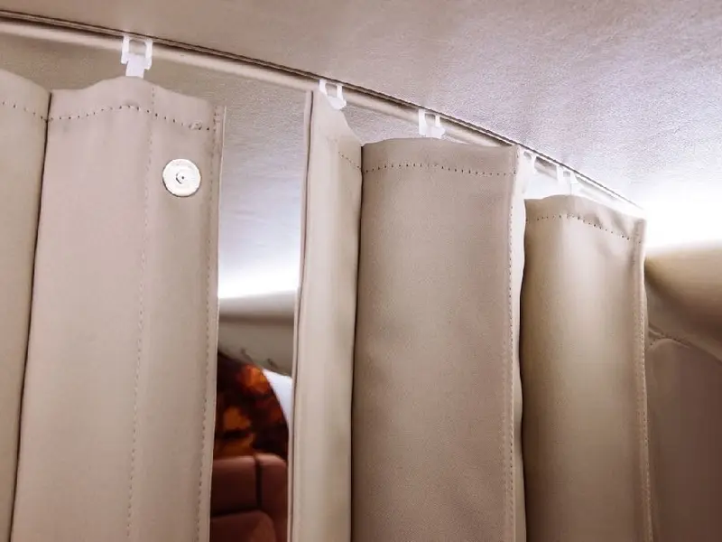 Cream curtains hanging from a curved ceiling rail