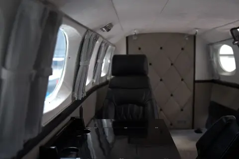 Business cabin with club seating in front of a quilted partition wall