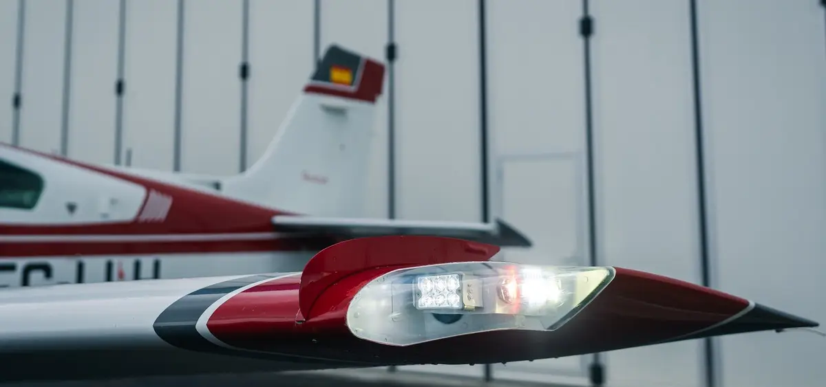 LED landing light on the wingtip of a red and white Beechcraft Bonanza in the hangar