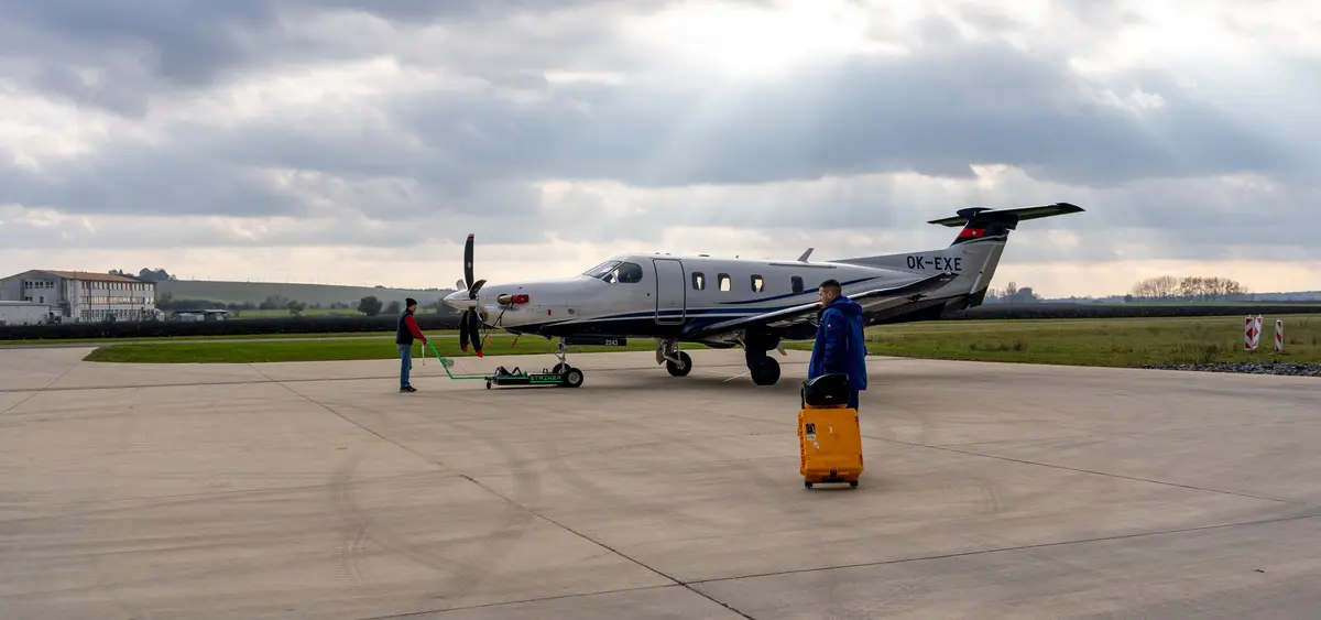 Pilatus PC-12 on the ramp with a technician and a tow bar