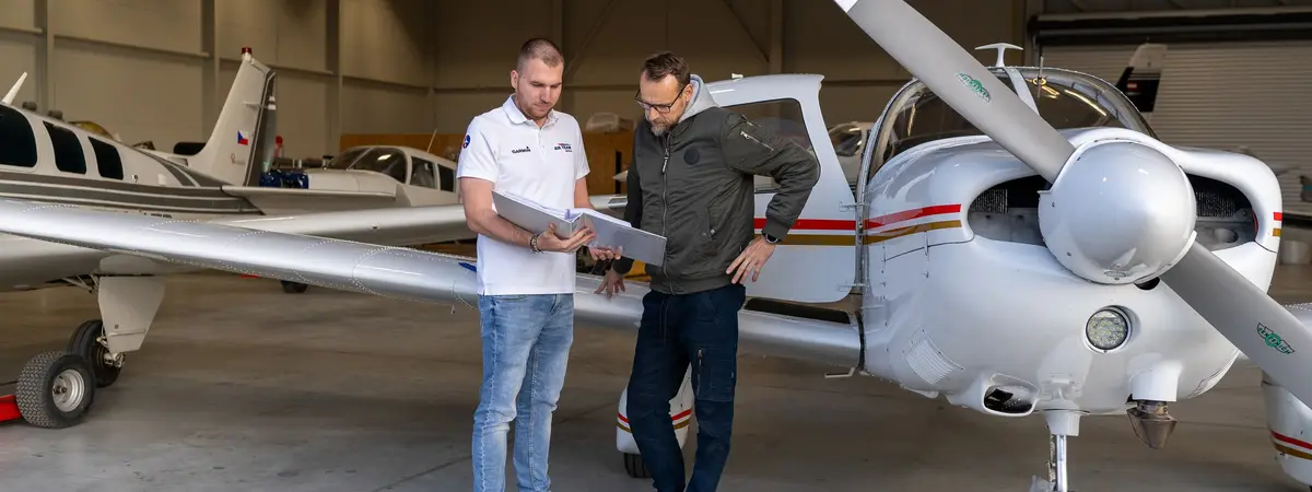 AIR TEAM technician handing over the aircraft documentation to the owner in the Kunovice hangar