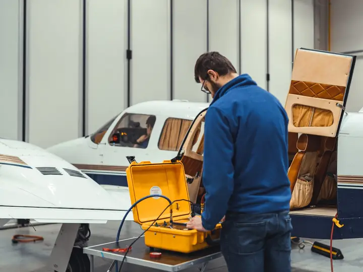 Technician with a test set at the cabin door of a Piper PA-34 Seneca