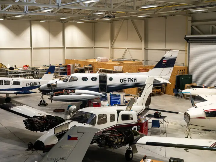 Several light aircraft inside the Kunovice hangar