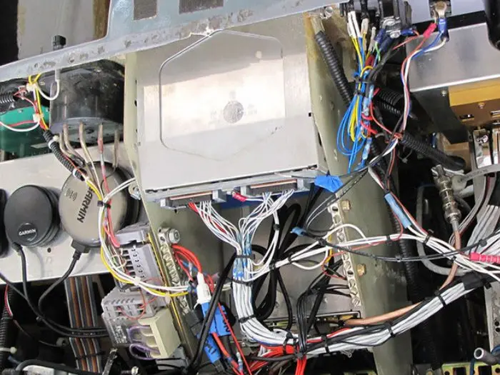 Harness routed through an open aircraft avionics bay