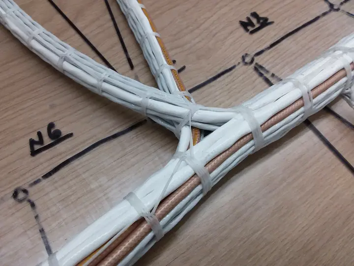 Wiring harness pinned to a formboard with a printed layout grid