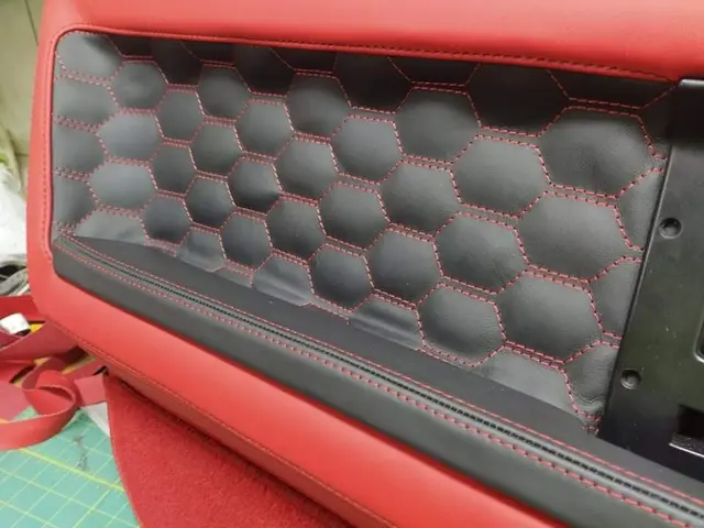 Black leather door panel with hexagon stitching and red thread on a red base