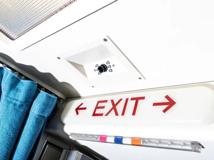 Cabin ceiling with a fitted exit sign and a crew rest curtain