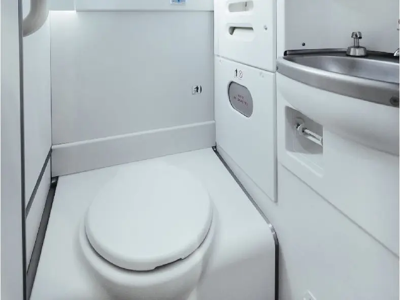 Upgraded aircraft lavatory with a white toilet, worktop and wash basin