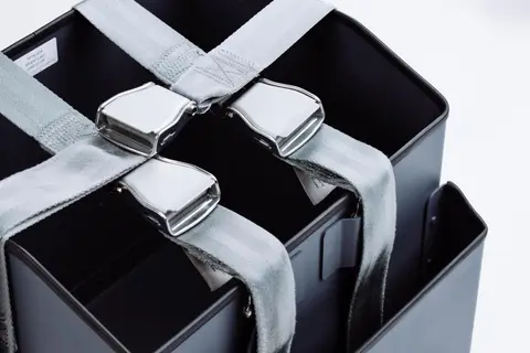Stowage bins with grey restraint straps and buckles
