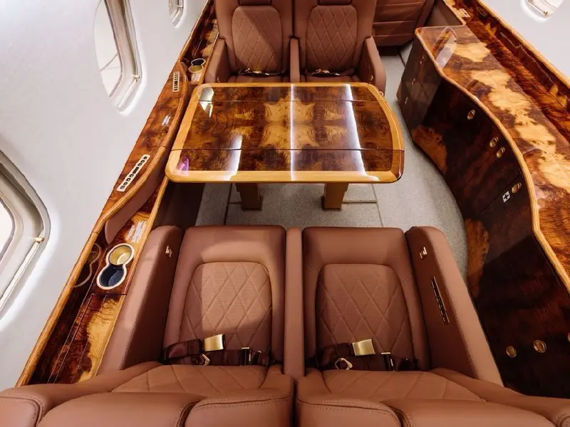 Aircraft cabin with a wood table and leather seats