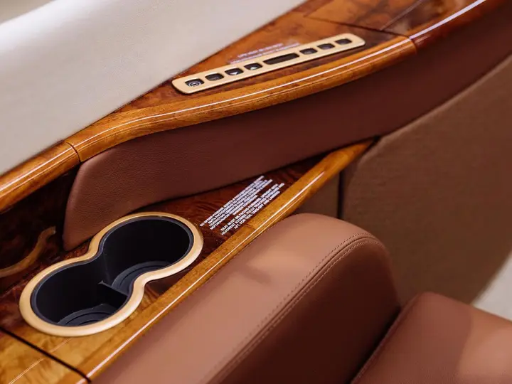 Cabin table in veneer wood between two leather seats